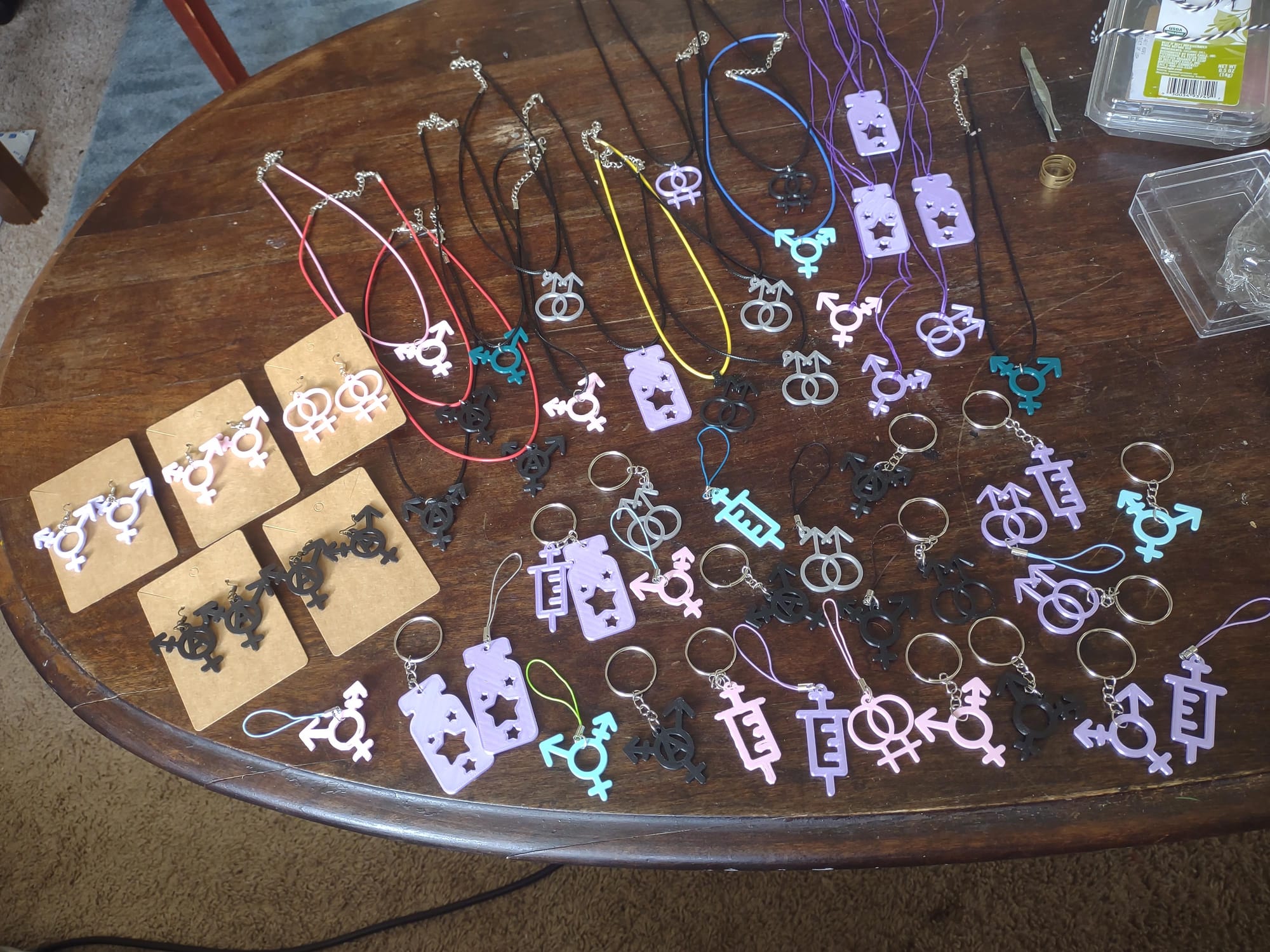 A wooden coffee table covered in a variety of plastic charms featuring gender symbols and syringes.